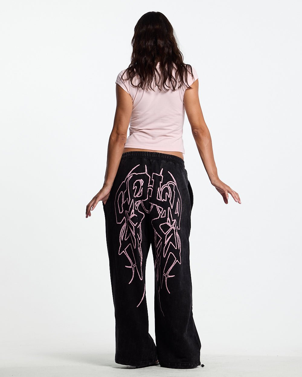 55 SWEATPANTS BLACK - washed black graphic sweatpants, back view on female model - Cold Culture #woman