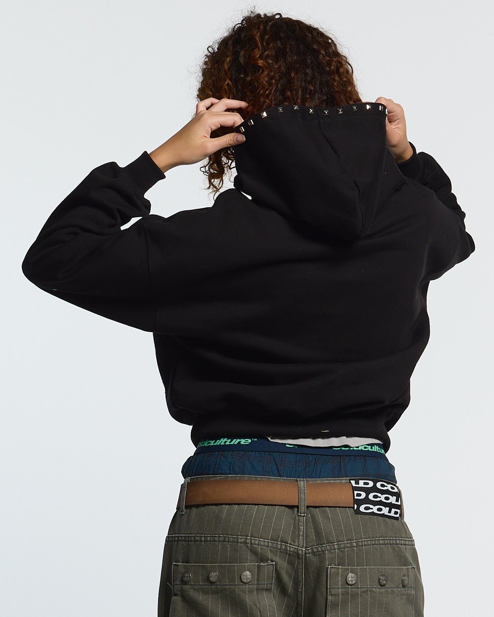 BADGES HOODIE BLACK - black studded hoodie, back view on female model - Cold Culture #woman