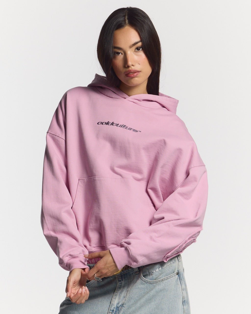 DISTRESS CURVED HOODIE PINK - pink distressed hoodie, front view on female model - Cold Culture #woman
