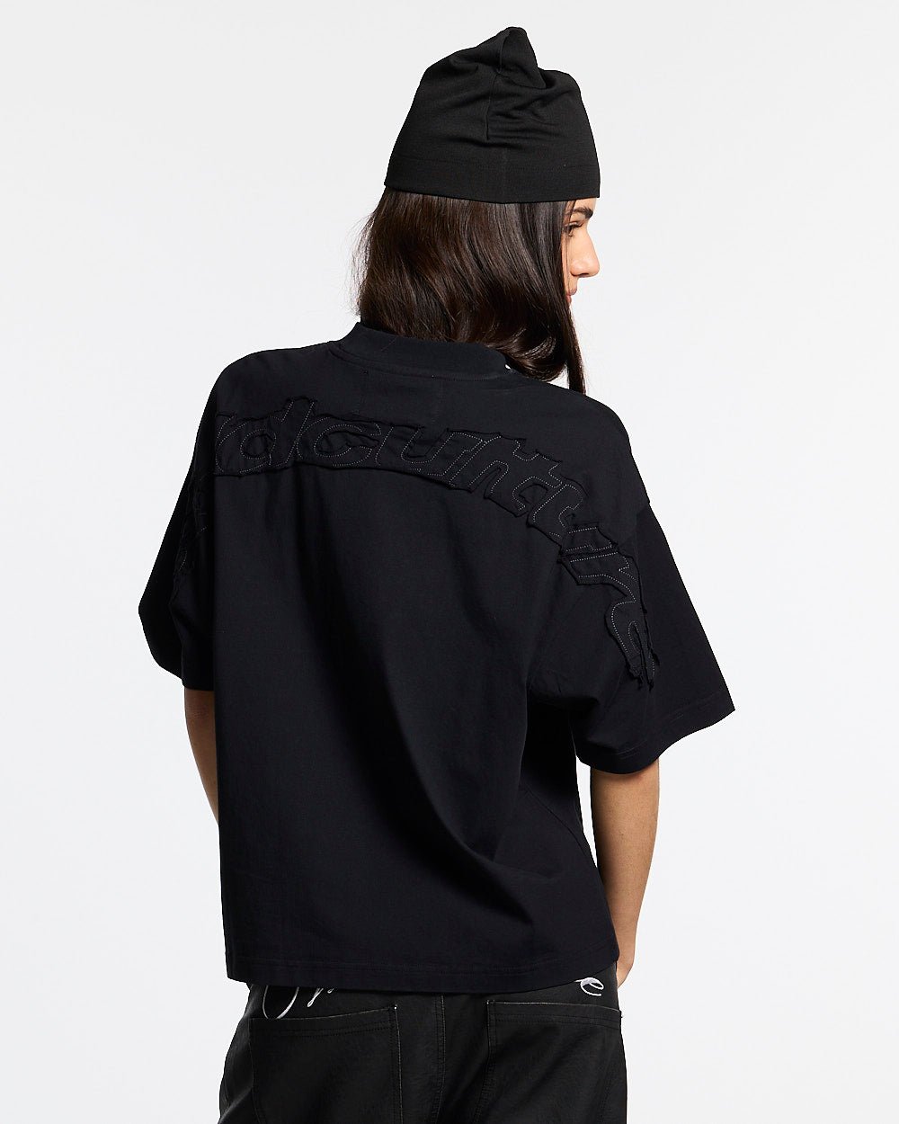 DISTRESS CURVED TEE BLACK - black distressed tee, back view on female model - Cold Culture #woman