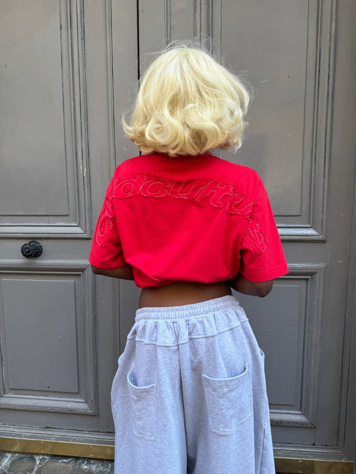 DISTRESS CURVED TEE RED - red distressed tee, back view on female model - Cold Culture #woman