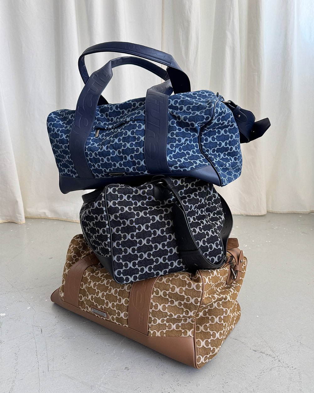 FEVER BAG BLUE - blue monogram duffle bag, flat lay with matching pieces - Cold Culture