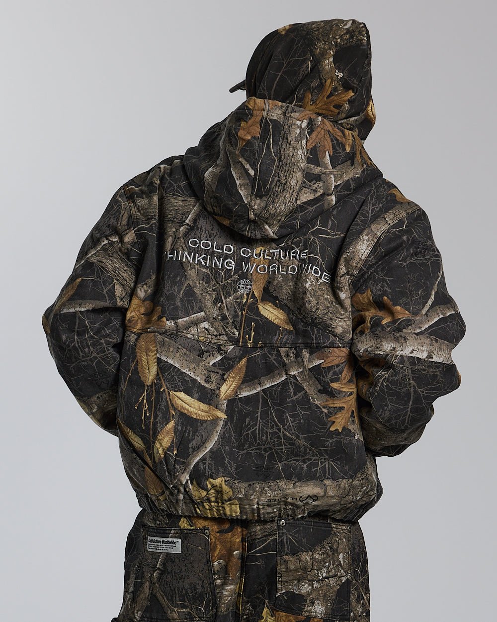 HOODED JACKET REALTREE BLACK - black realtree camo hooded jacket, back view on male model - Cold Culture