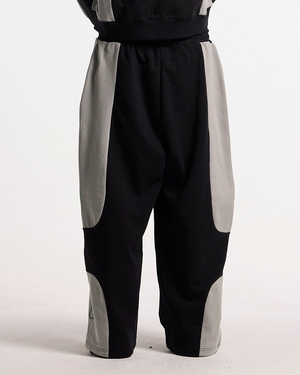 RIDER SWEATPANTS BLACK & GREY - black and grey paneled sweatpants, back view on male model - Cold Culture