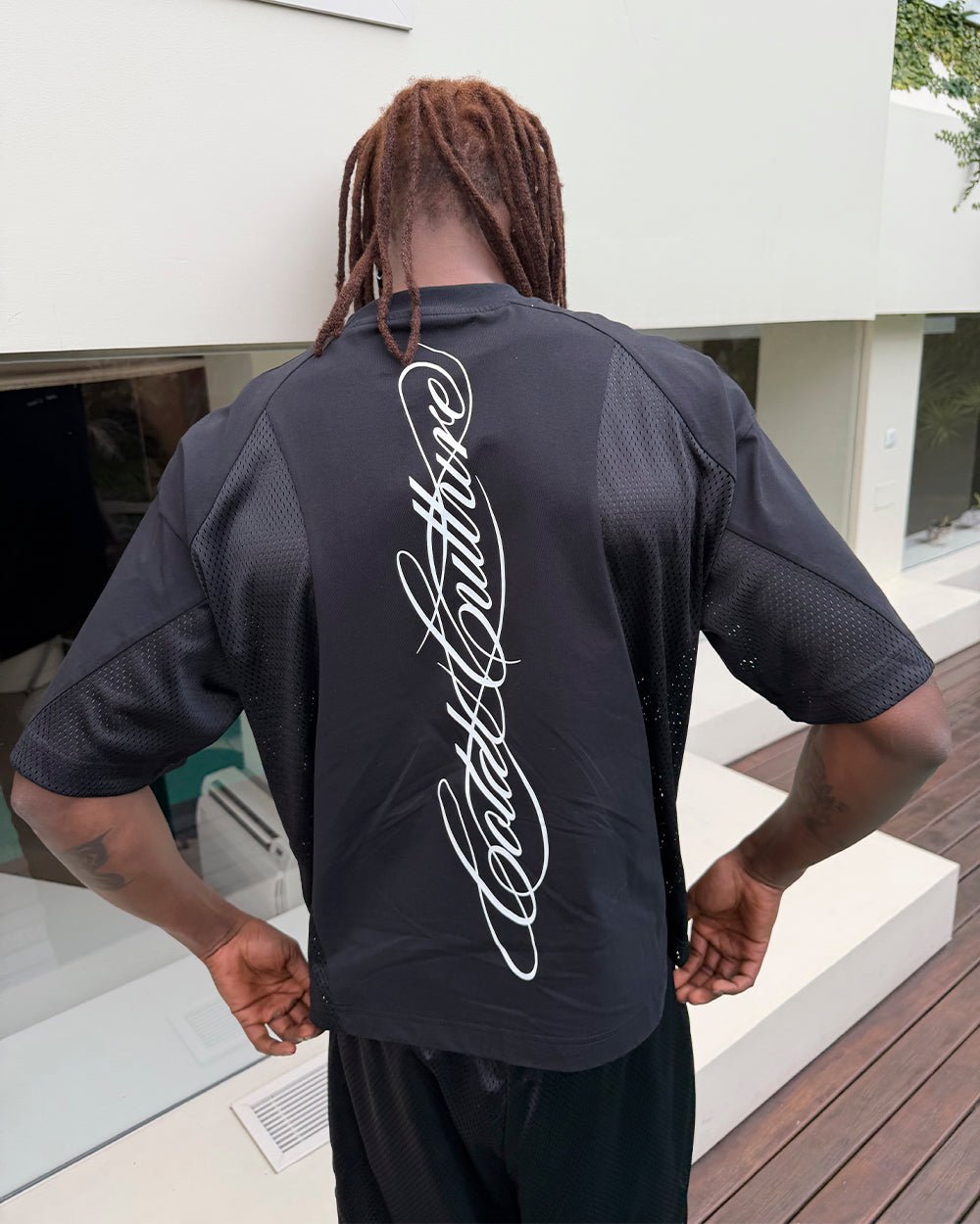 RIOT MESH TEE BLACK - black mesh panel tee, back view on male model - Cold Culture