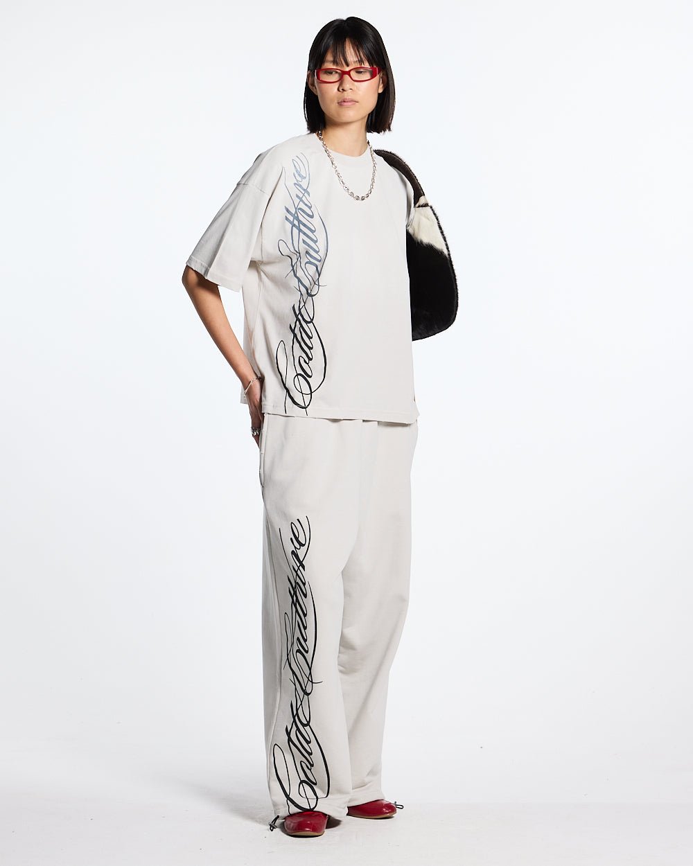 SCRIPT SWEATPANTS LIGHT GREY - light grey script print sweatpants, front view on female model - Cold Culture #woman