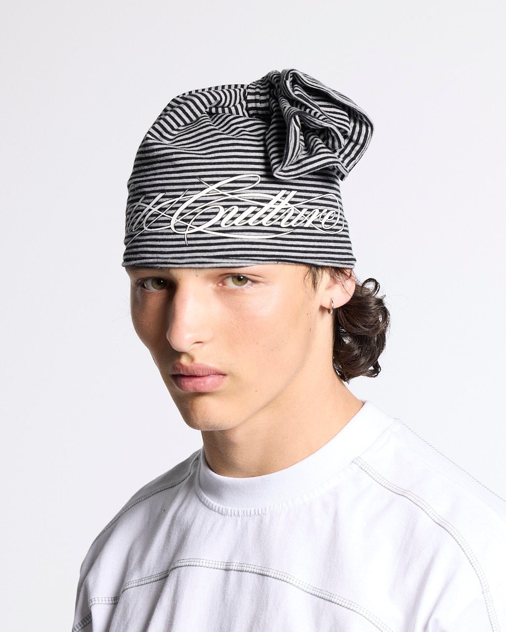 SCRIPTED STRIPES KNOT BEANIE BLACK - black striped knot beanie, front view on male model - Cold Culture #man