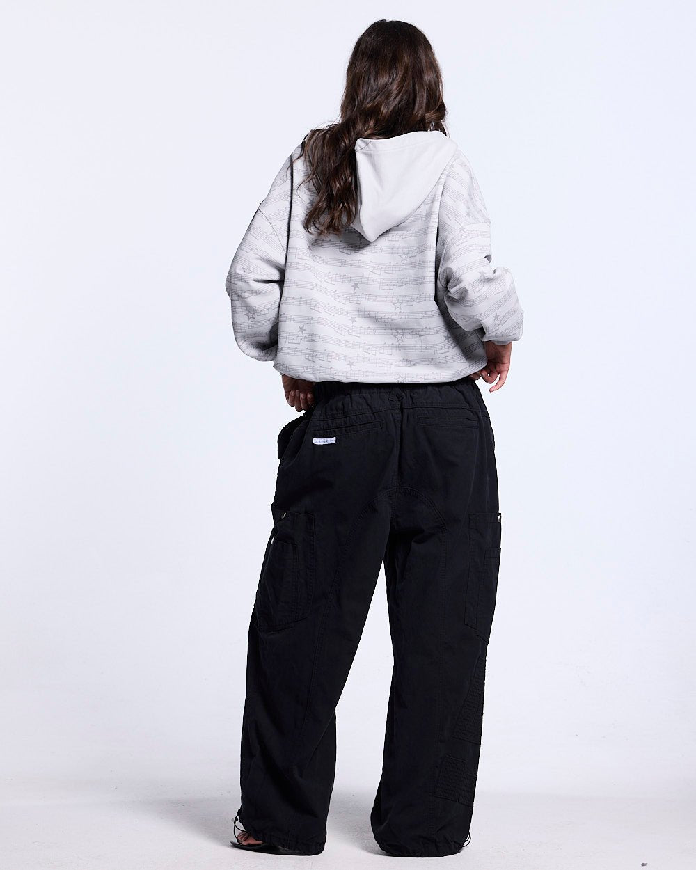 SOLID CARGO PANTS BLACK - black cargo pants, back view on female model - Cold Culture #woman