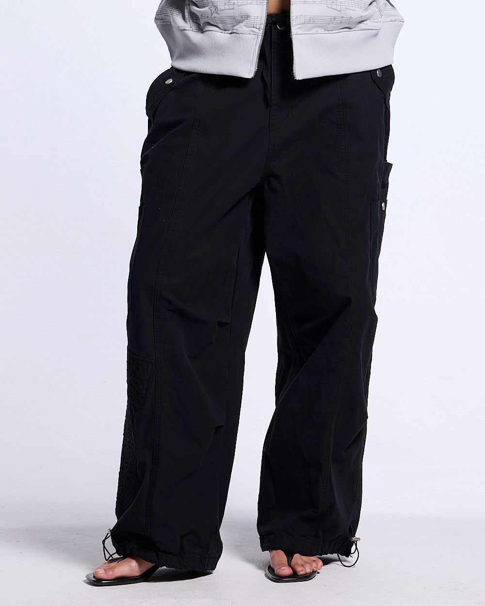SOLID CARGO PANTS BLACK - black cargo pants, front view on female model - Cold Culture