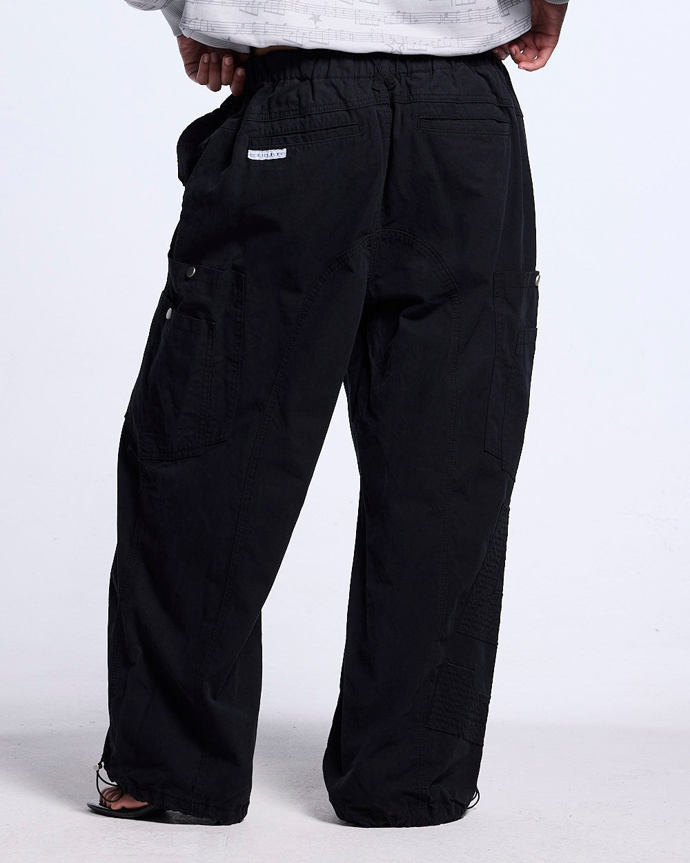 SOLID CARGO PANTS BLACK - black cargo pants, back view on male model - Cold Culture