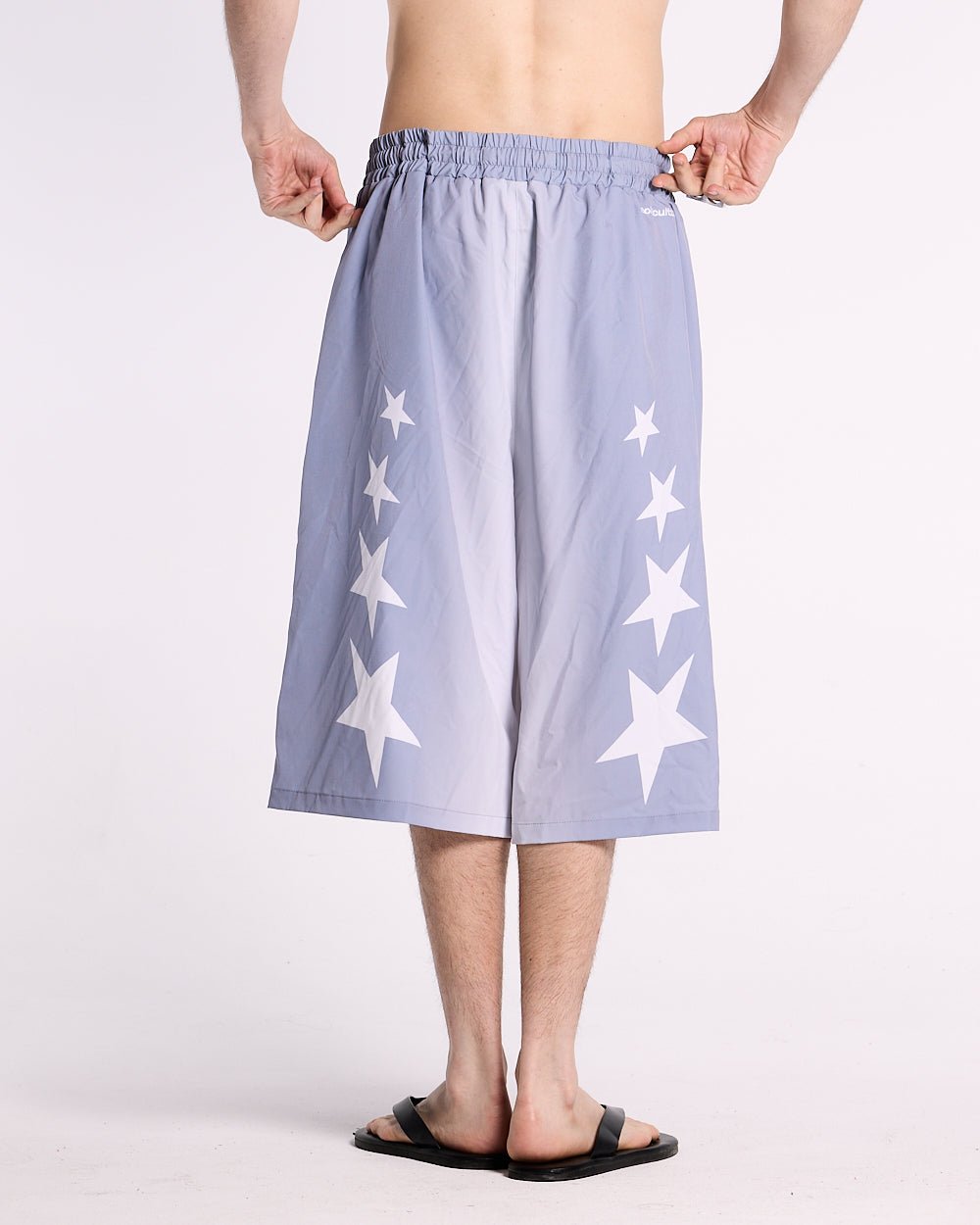 STARS WIDE SWIM SHORTS LILAC - lilac star print swim shorts, back view on male model - Cold Culture