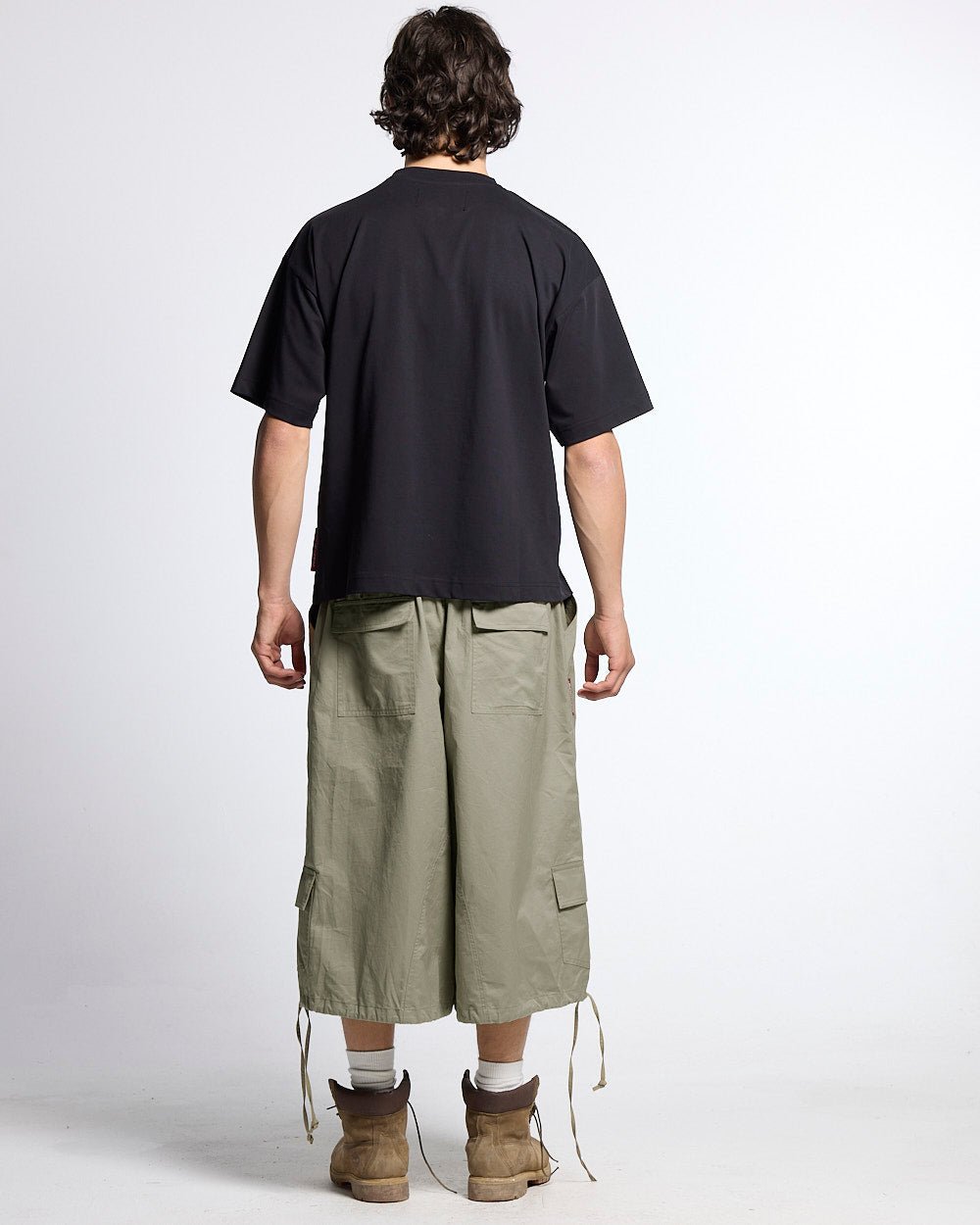 UTILITARY CAPRI PARACHUTE CREAM - khaki cargo capri shorts, back view on male model - Cold Culture #man
