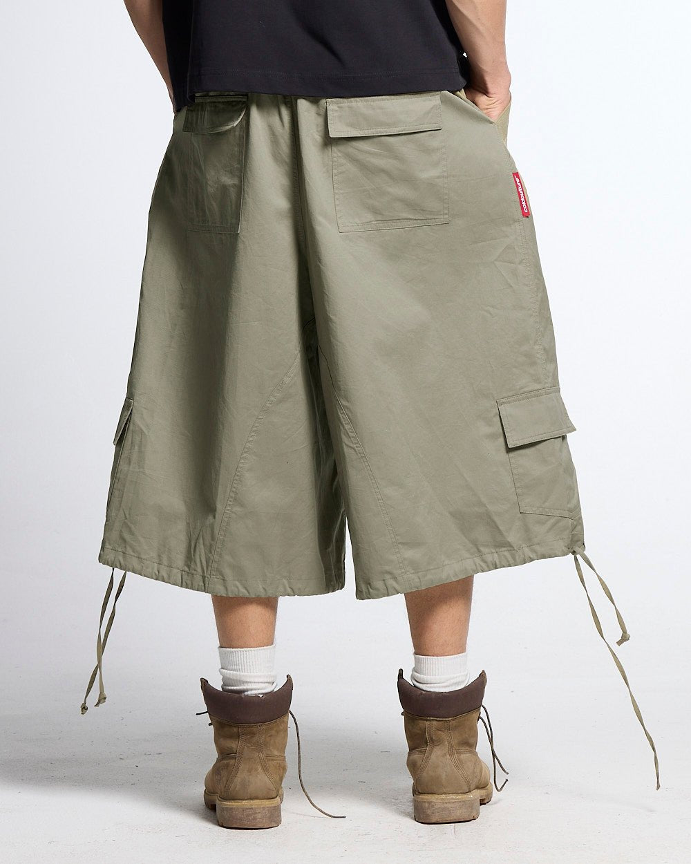 UTILITARY CAPRI PARACHUTE CREAM - khaki cargo capri shorts, back view on male model - Cold Culture