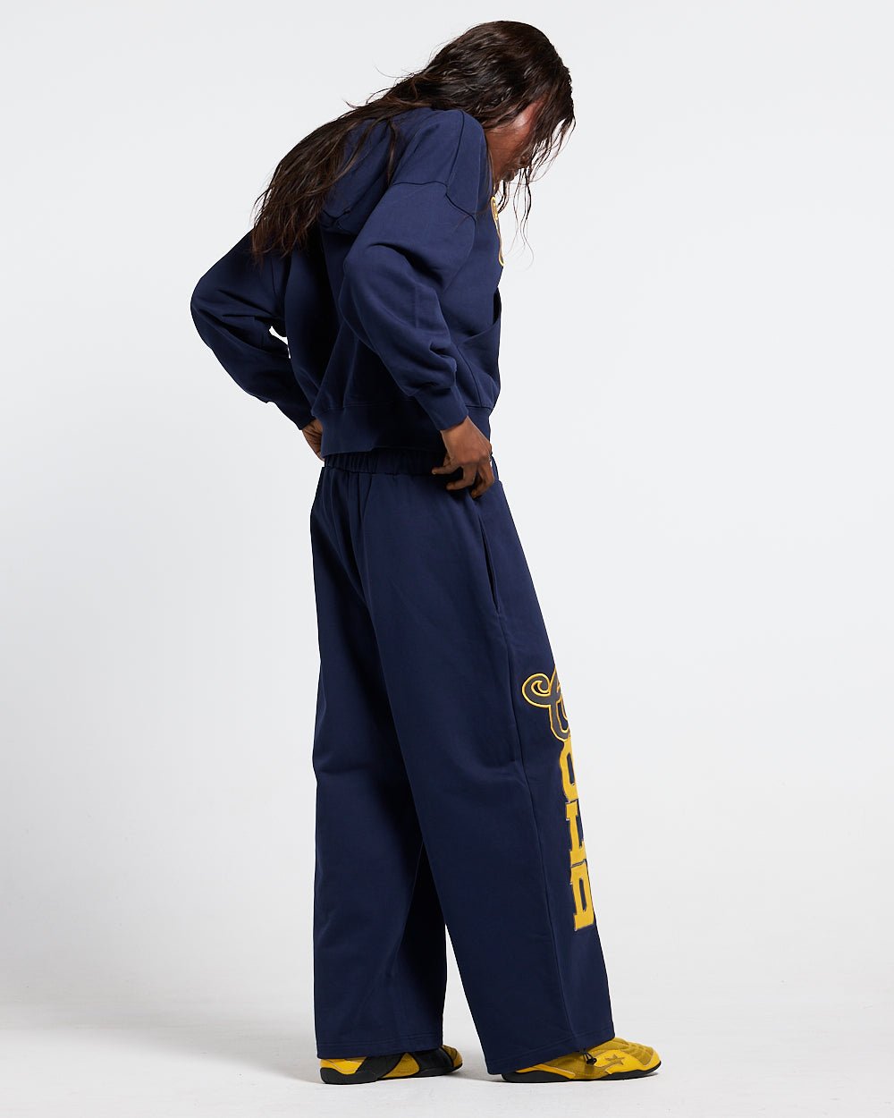 VARSITY HOODIE DARK BLUE - navy blue varsity print hoodie, back view on female model - Cold Culture #woman