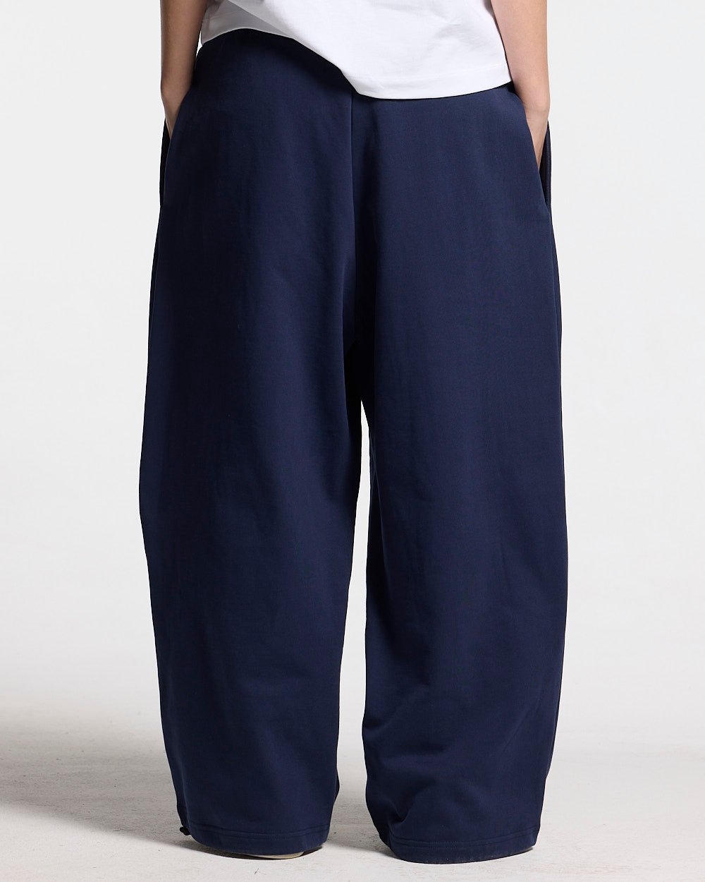 VARSITY PANTS DARK BLUE - navy blue baggy sweatpants, back view on female model - Cold Culture #woman