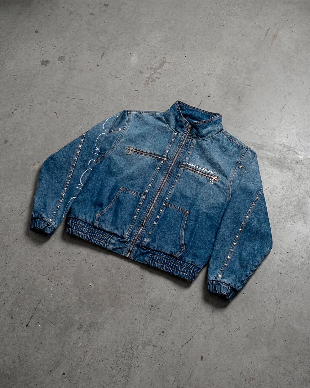 2010 DENIM JACKET BLUE DENIM - blue studded denim jacket, flat lay - Cold Culture