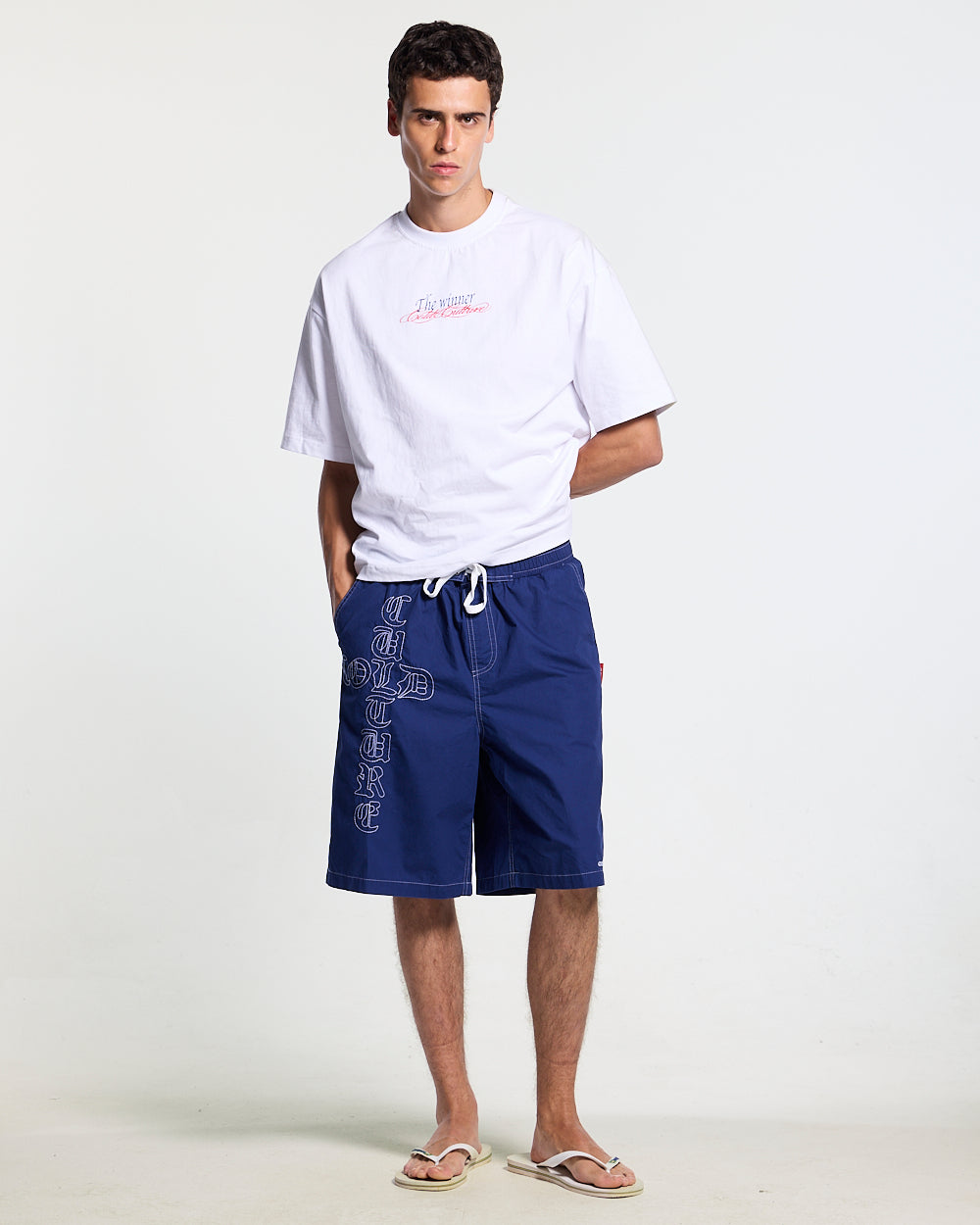 CROSSED SWIMSHORTS BLUE - navy gothic print swim shorts, front view on male model - Cold Culture #man