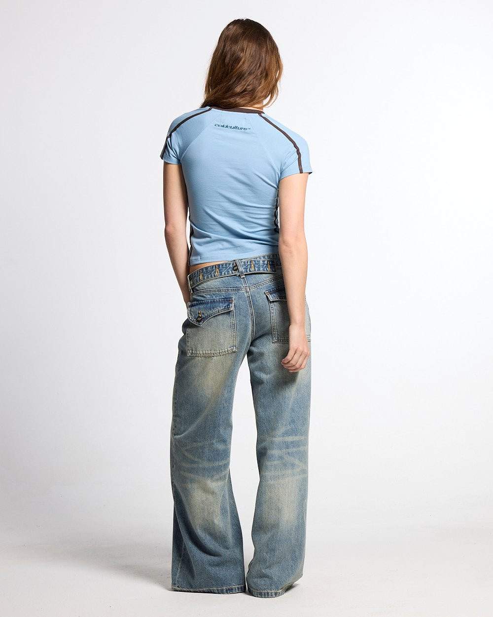BANDAL BABY TEE BLUE - light blue varsity baby tee, back view on female model - Cold Culture #woman