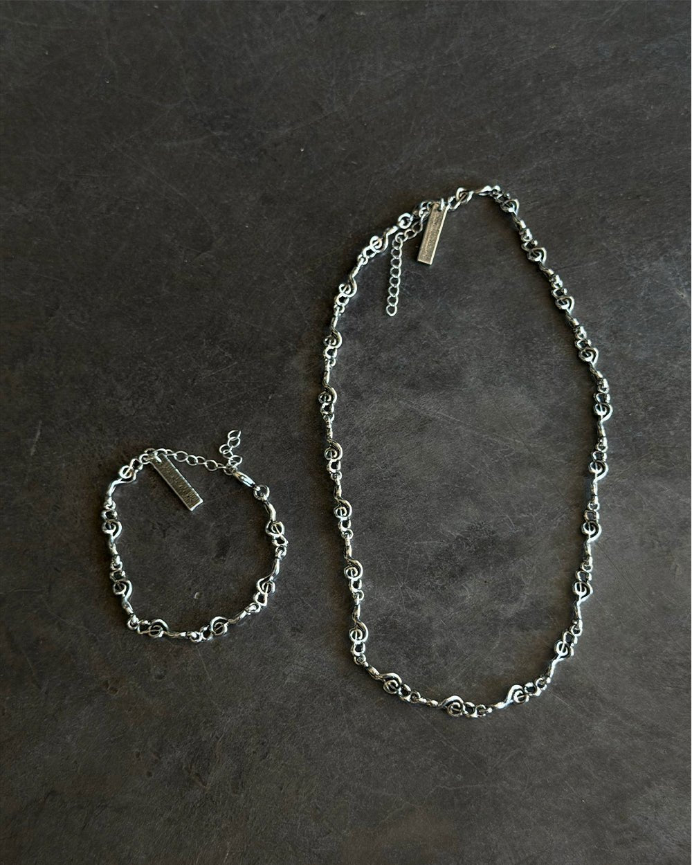 BEAT IT BRACELET SILVER - silver treble clef chain bracelet, flat lay with matching pieces - Cold Culture