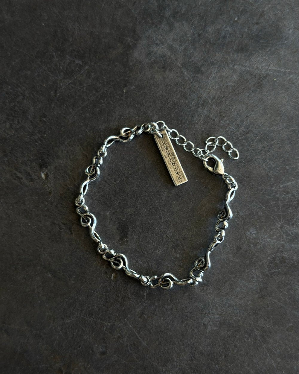 BEAT IT BRACELET SILVER - silver treble clef chain bracelet, flat lay - Cold Culture