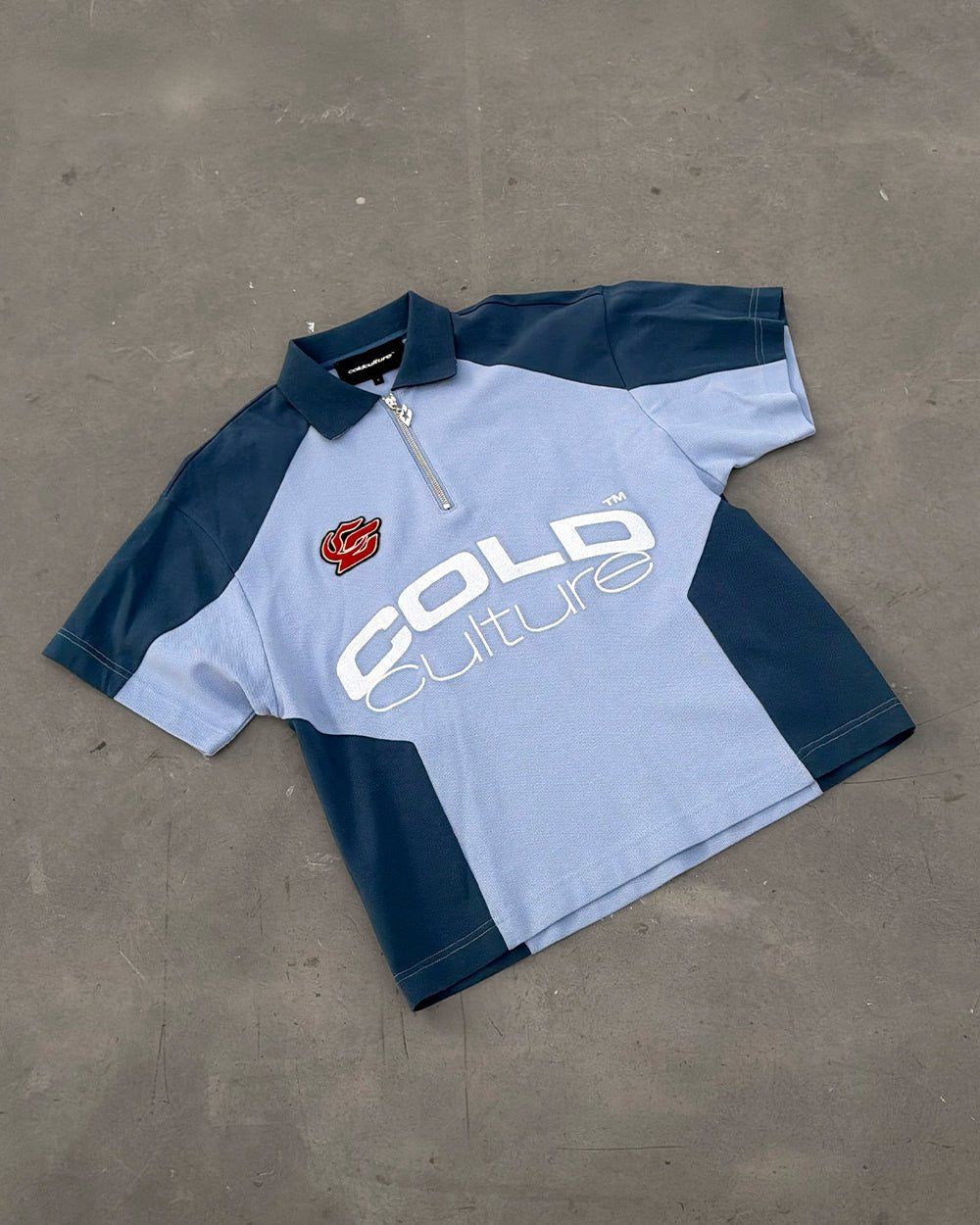 BIKER POLO LIGHT BLUE - light blue half-zip polo, flat lay - Cold Culture
