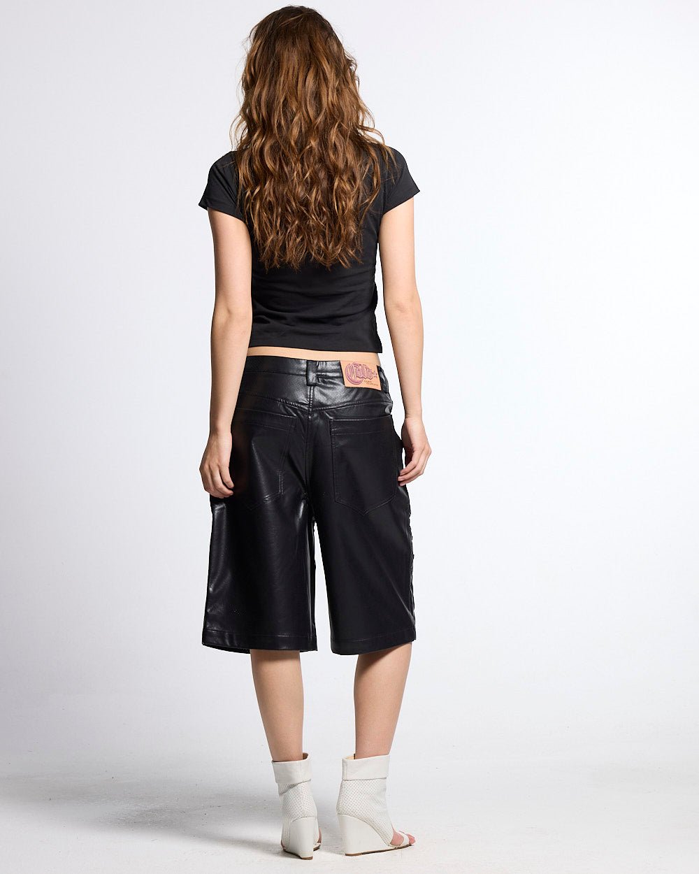 BRAVE SHORTS BLACK - black faux leather shorts, back view on female model - Cold Culture #woman