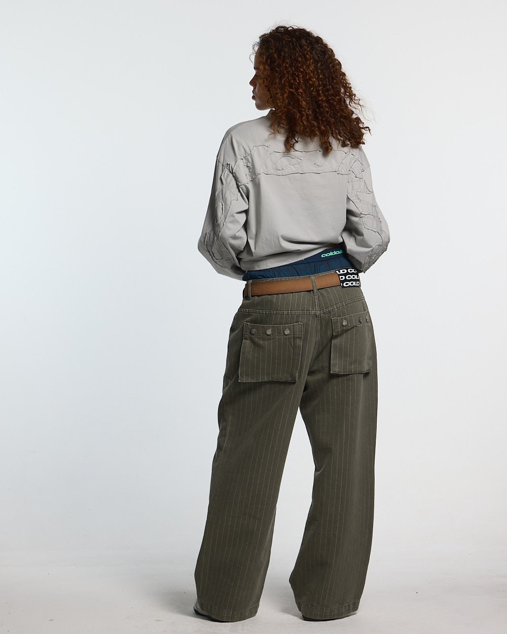 CASINO PANTS GREEN DENIM - green pinstripe denim pants, back view on female model - Cold Culture #woman