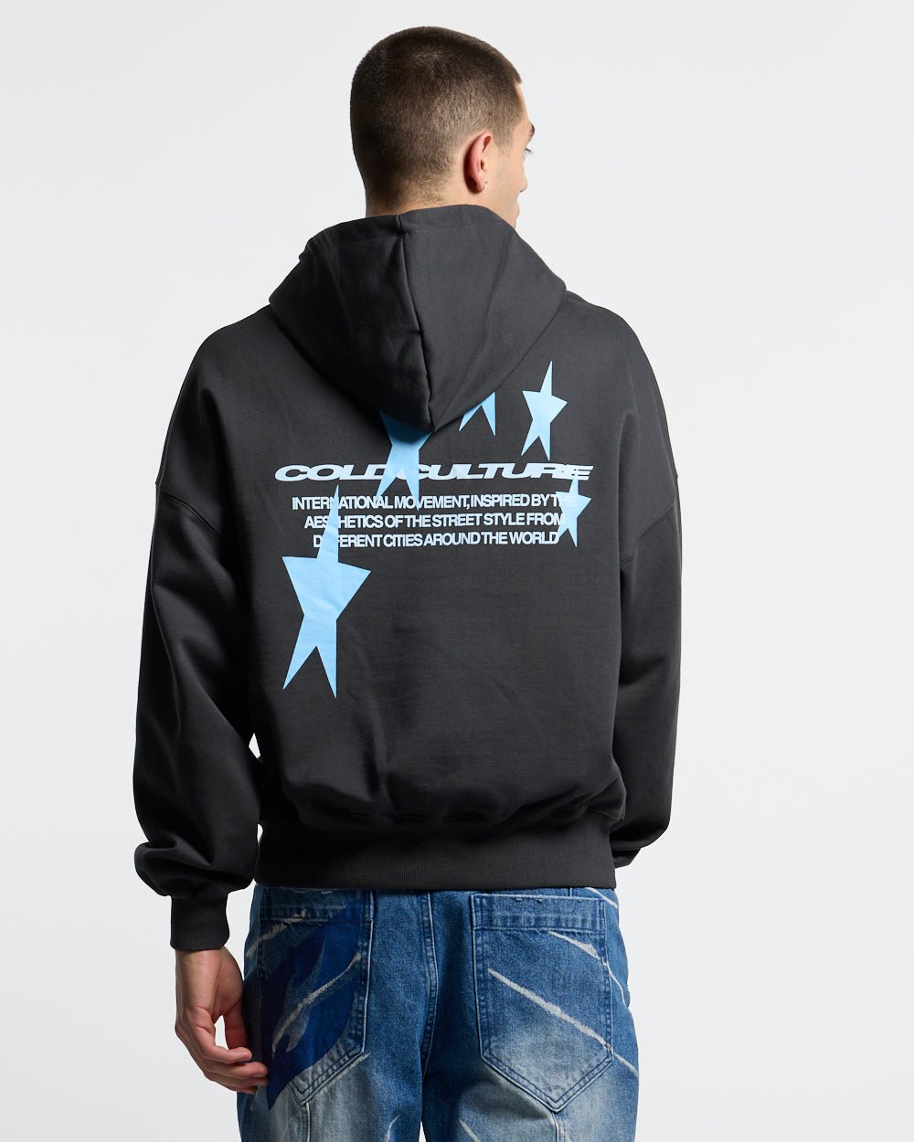 COSMOS ARC HOODIE INDIA INK - washed black star print hoodie, back view on male model - Cold Culture