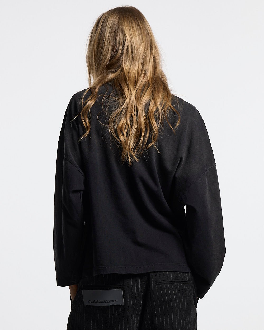 CROSSED SCRIPT LONGSLEEVE 2.0 BLACK - black script print longsleeve tee, back view on female model - Cold Culture #woman