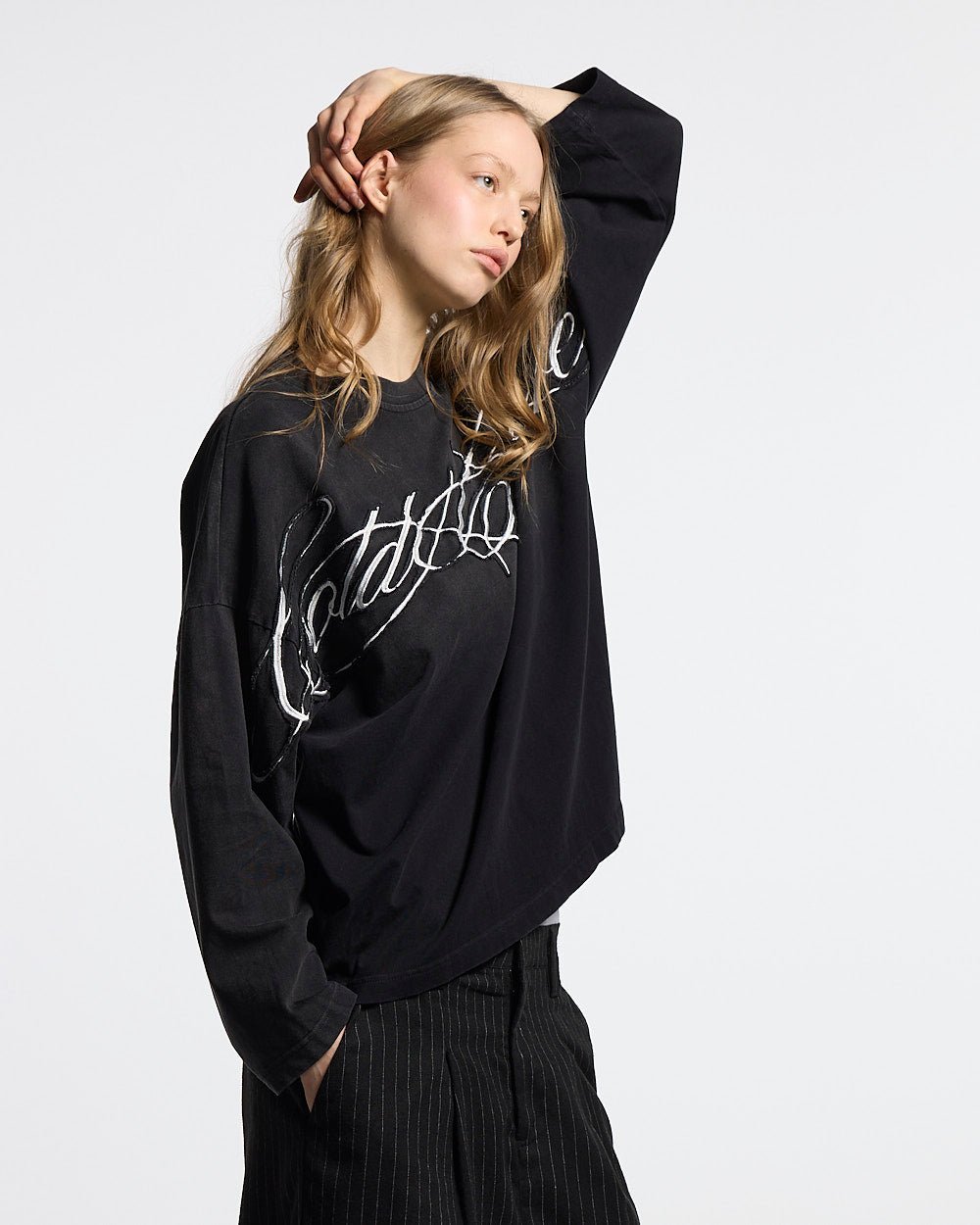 CROSSED SCRIPT LONGSLEEVE 2.0 BLACK - black script print longsleeve tee, front view on female model - Cold Culture #woman