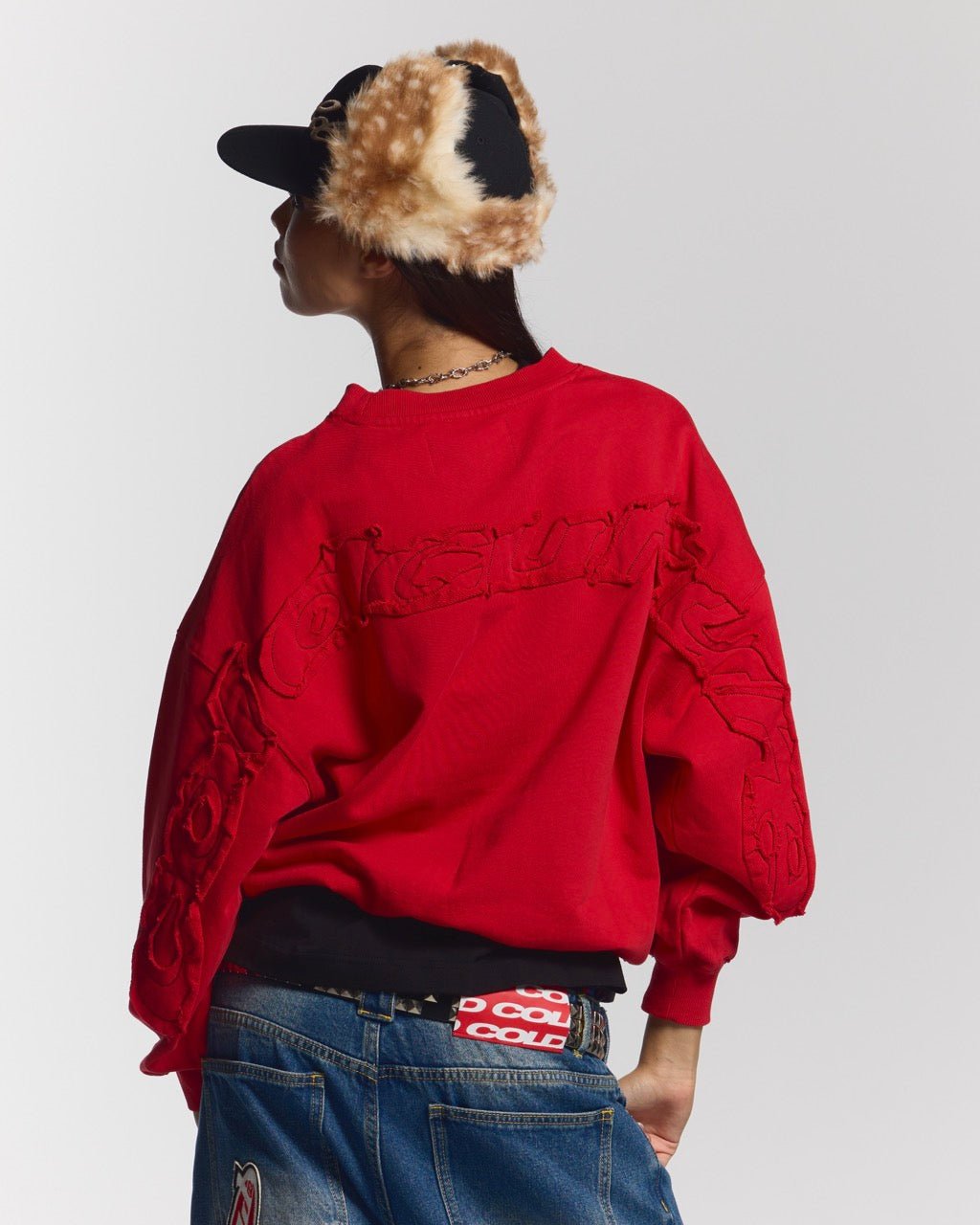 DISTRESS CURVED CREWNECK RED - red distressed crewneck sweatshirt, back view on female model - Cold Culture #woman