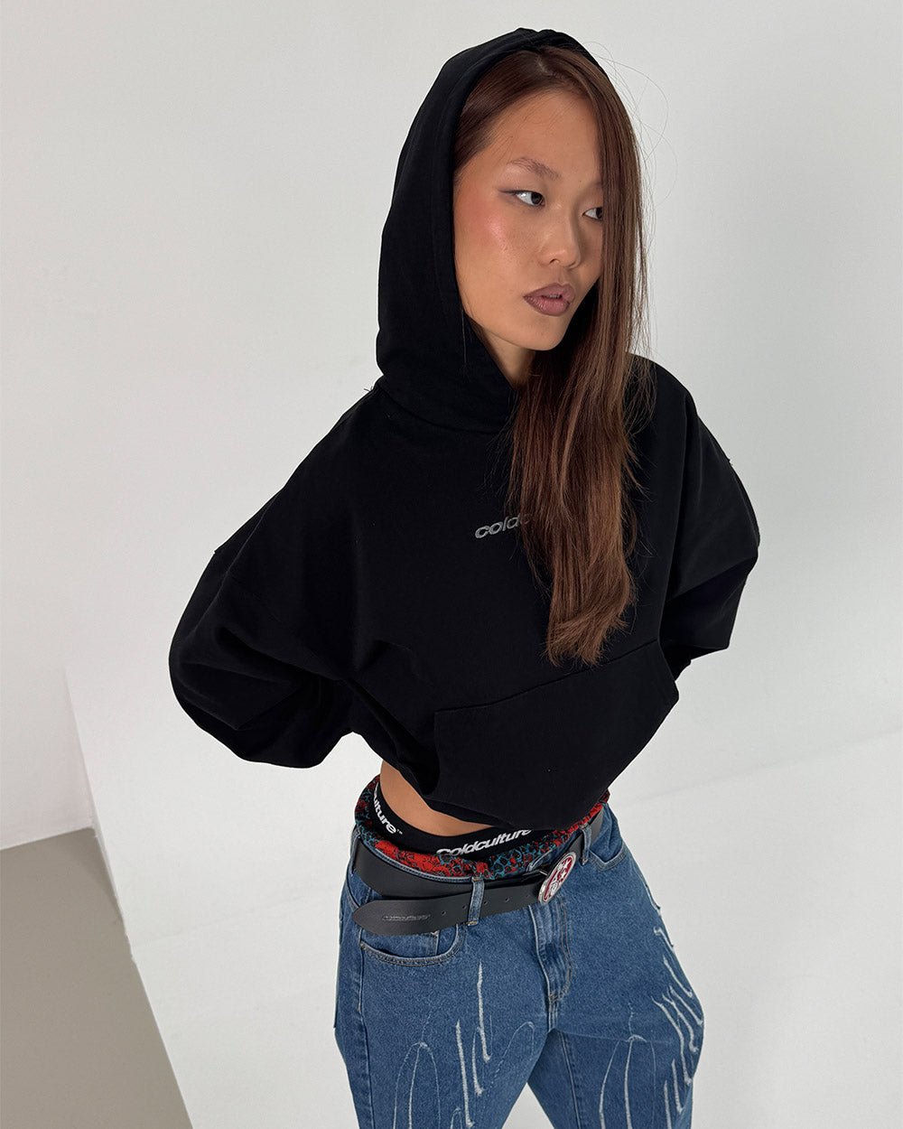 DISTRESS CURVED HOODIE BLACK - black distressed hoodie, front view on female model - Cold Culture #woman