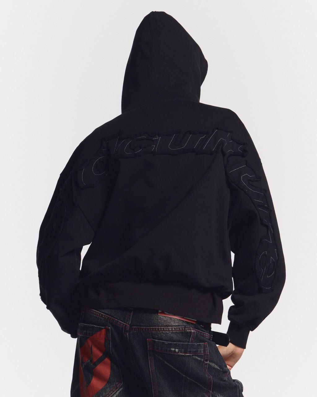 DISTRESS CURVED HOODIE BLACK - black distressed hoodie, back view on female model - Cold Culture #woman