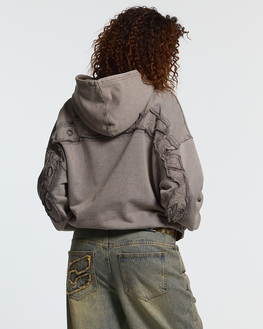 DISTRESS CURVED HOODIE WASHED GREY - washed grey distressed hoodie, back view on female model - Cold Culture #woman