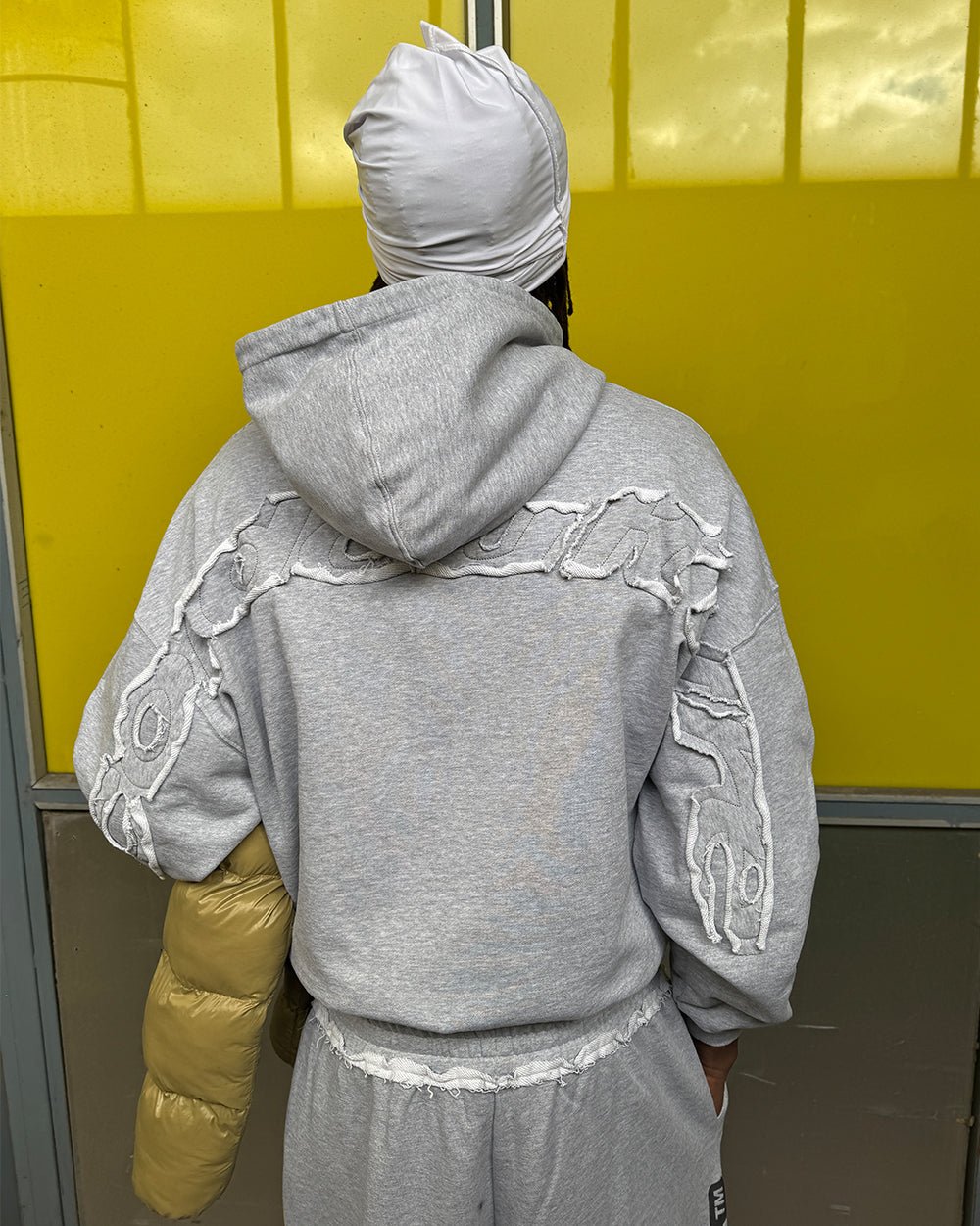 DISTRESS CURVED HOODIE LIGHT GREY - light grey distressed hoodie, street style shot - Cold Culture