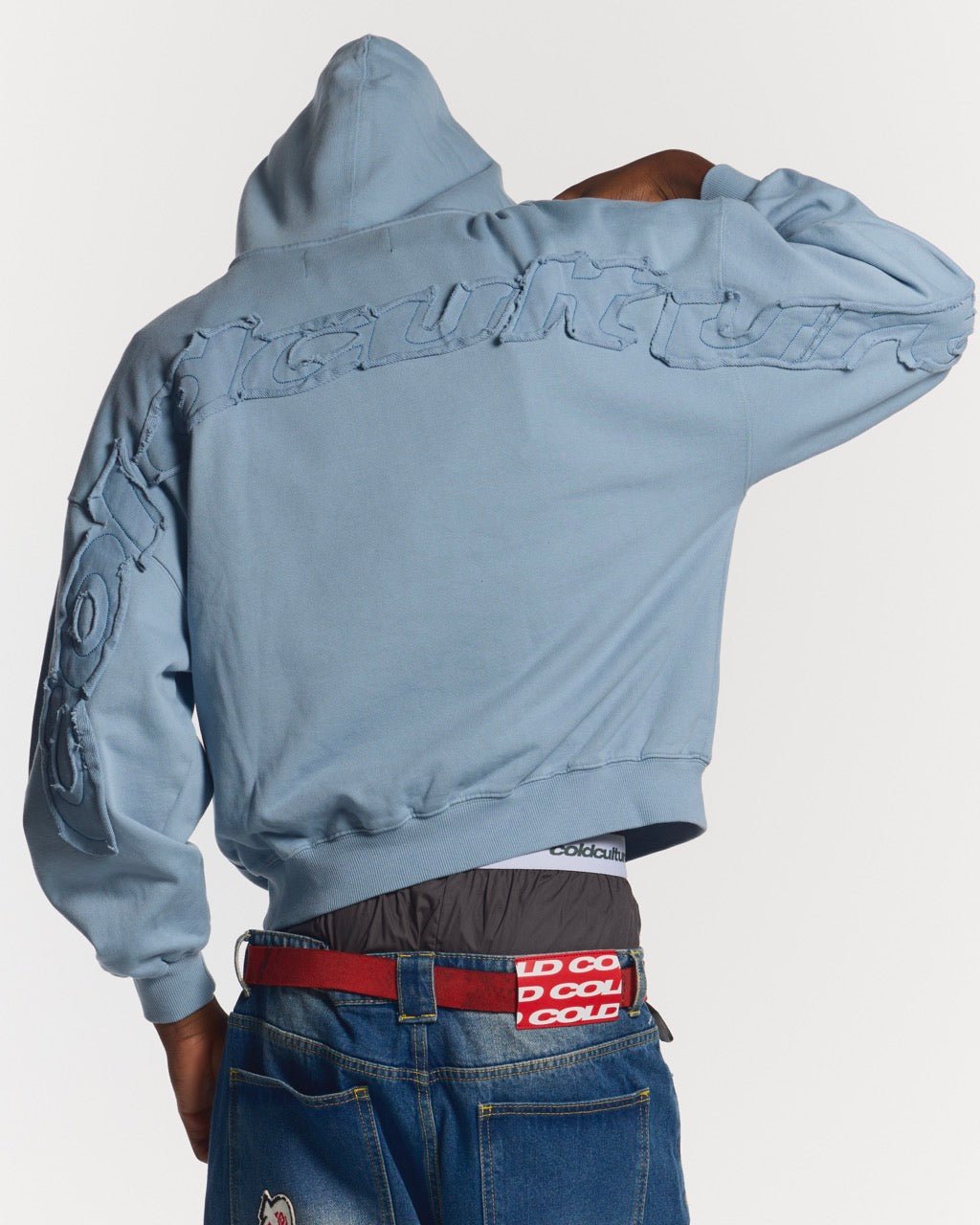 DISTRESS CURVED HOODIE SHADY BLUE - light blue distressed hoodie, back view on male model - Cold Culture