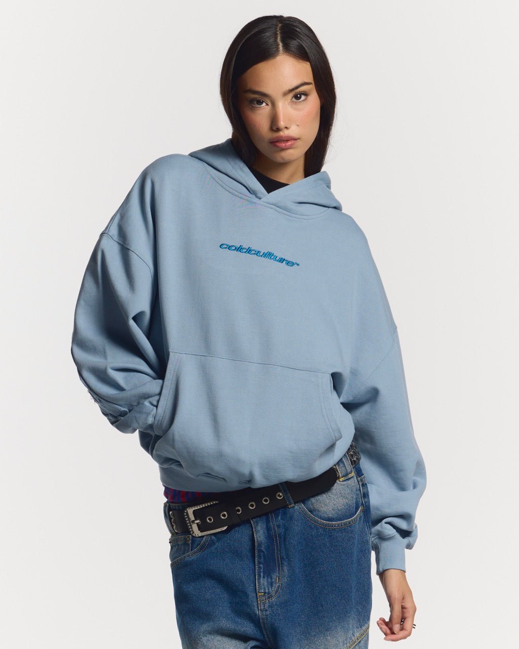 DISTRESS CURVED HOODIE SHADY BLUE - light blue distressed hoodie, front view on female model - Cold Culture #woman