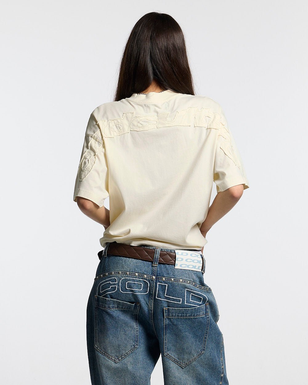 DISTRESS CURVED TEE CREAM - cream distressed tee, back view on female model - Cold Culture #woman
