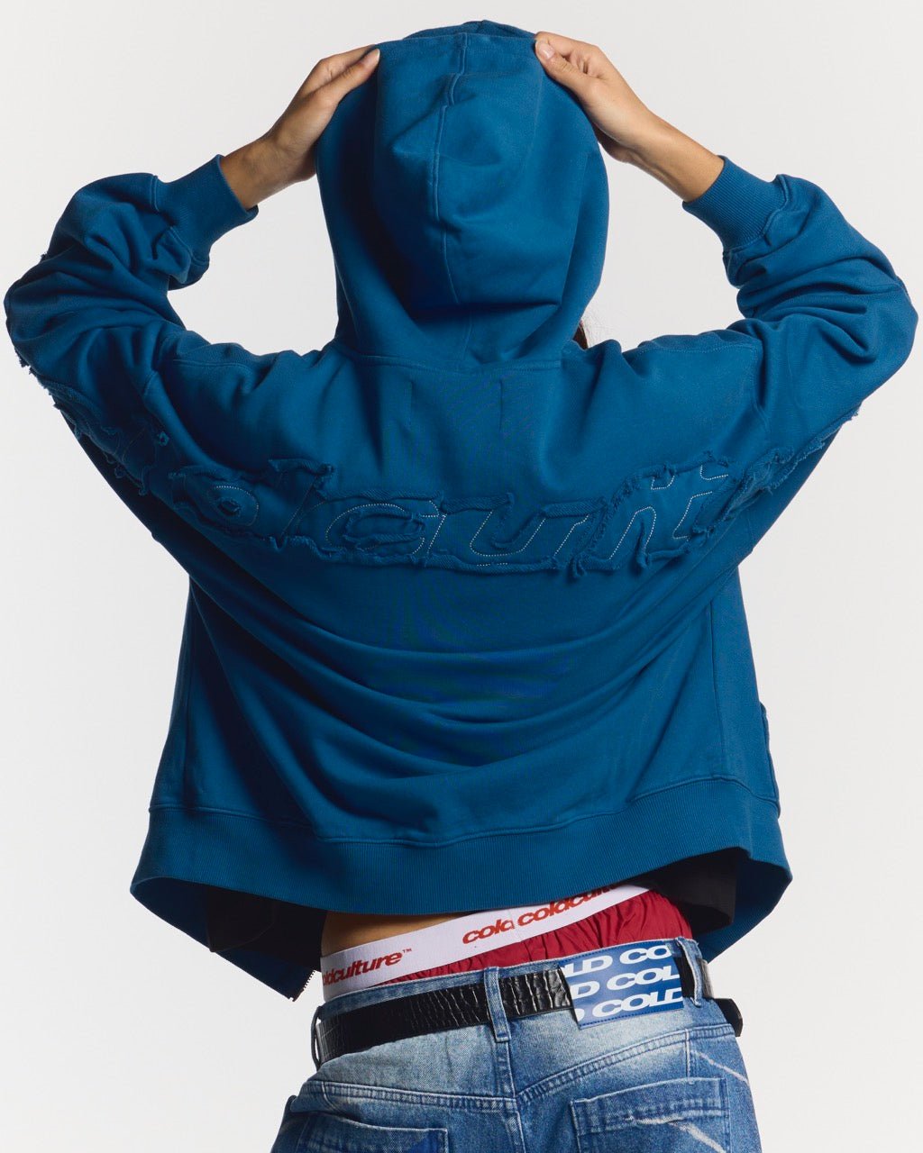 DISTRESS CURVED ZIP HOODIE DARK BLUE - dark blue distressed zip-up hoodie, back view on female model - Cold Culture #woman