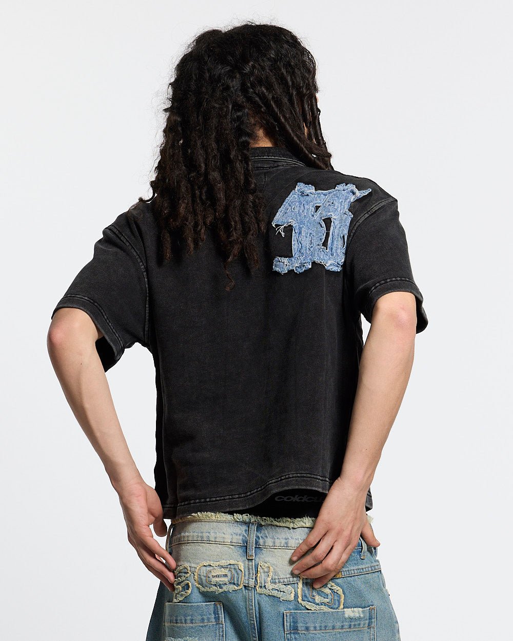 DISTRESSED DOLLAR POLO BLACK - black polo with denim applique, back view on male model - Cold Culture #man
