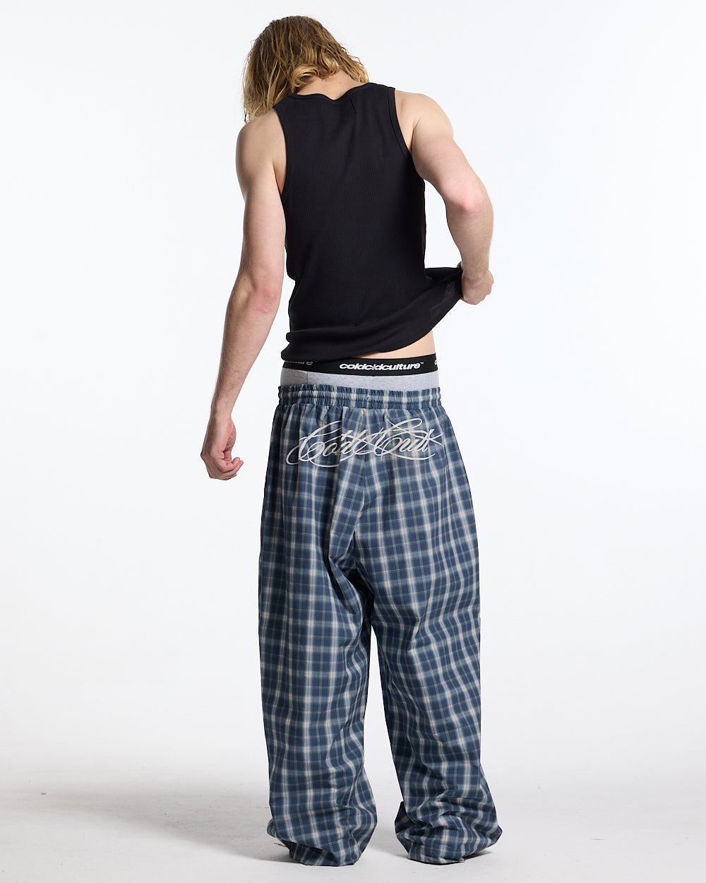 LIAR PANTS BLUE - blue plaid women's sweatpants, back view on male model - Cold Culture #man