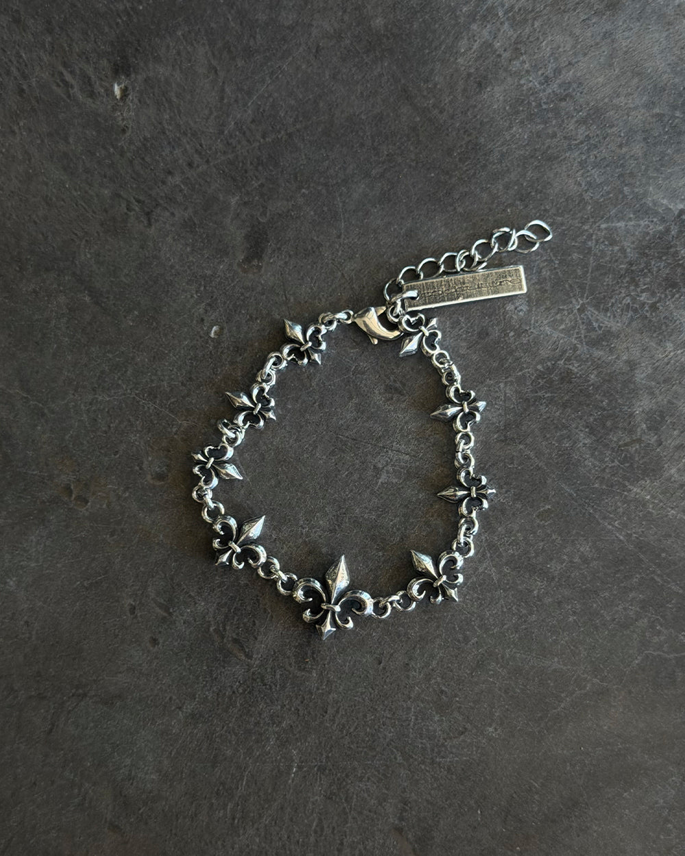 LOOSE ICON BRACELET SILVER - silver fleur-de-lis chain bracelet, flat lay - Cold Culture