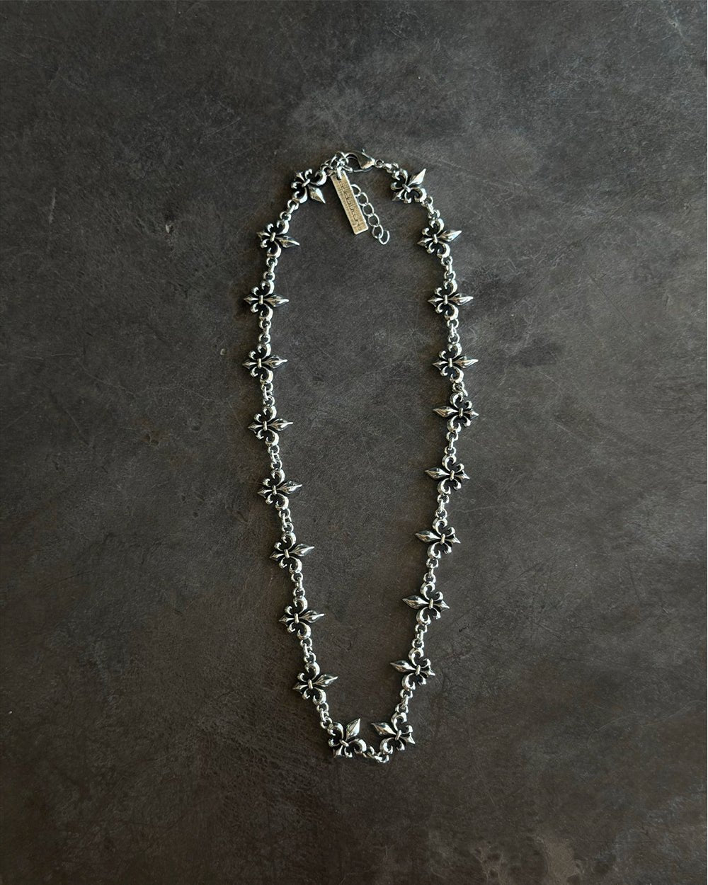 LOOSE ICON NECKLACE SILVER - silver fleur-de-lis chain necklace, flat lay - Cold Culture