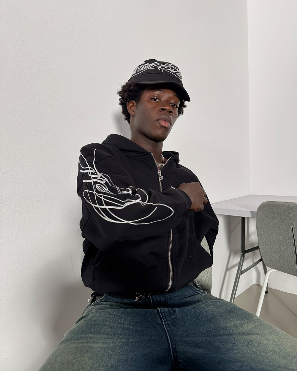 NEW SCRIPT ZIP HOODIE BLACK - black embroidered zip-up hoodie, front view on male model - Cold Culture
