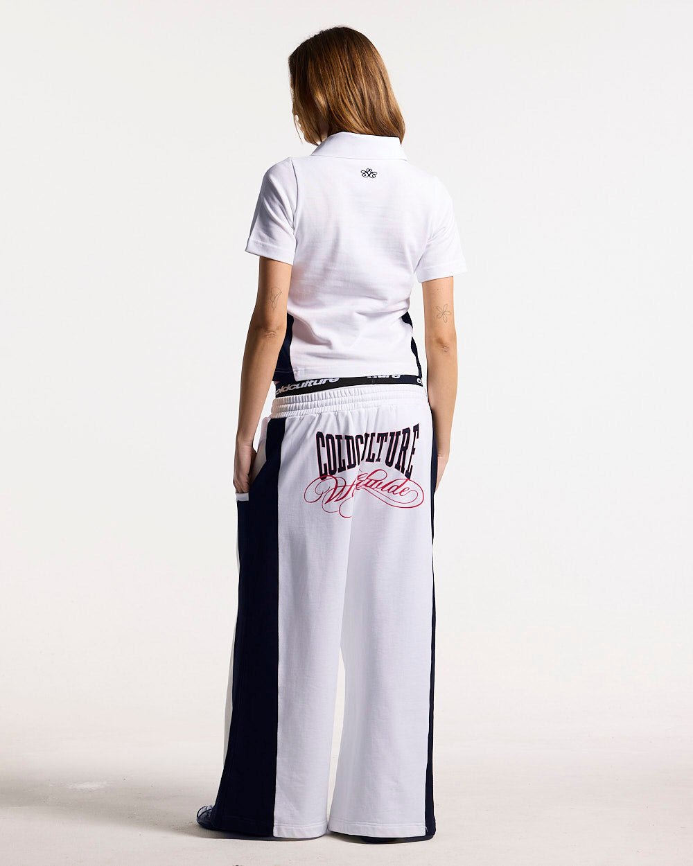 NIA SET POLO WHITE & BLACK - white and black polo shirt, back view on female model - Cold Culture #woman