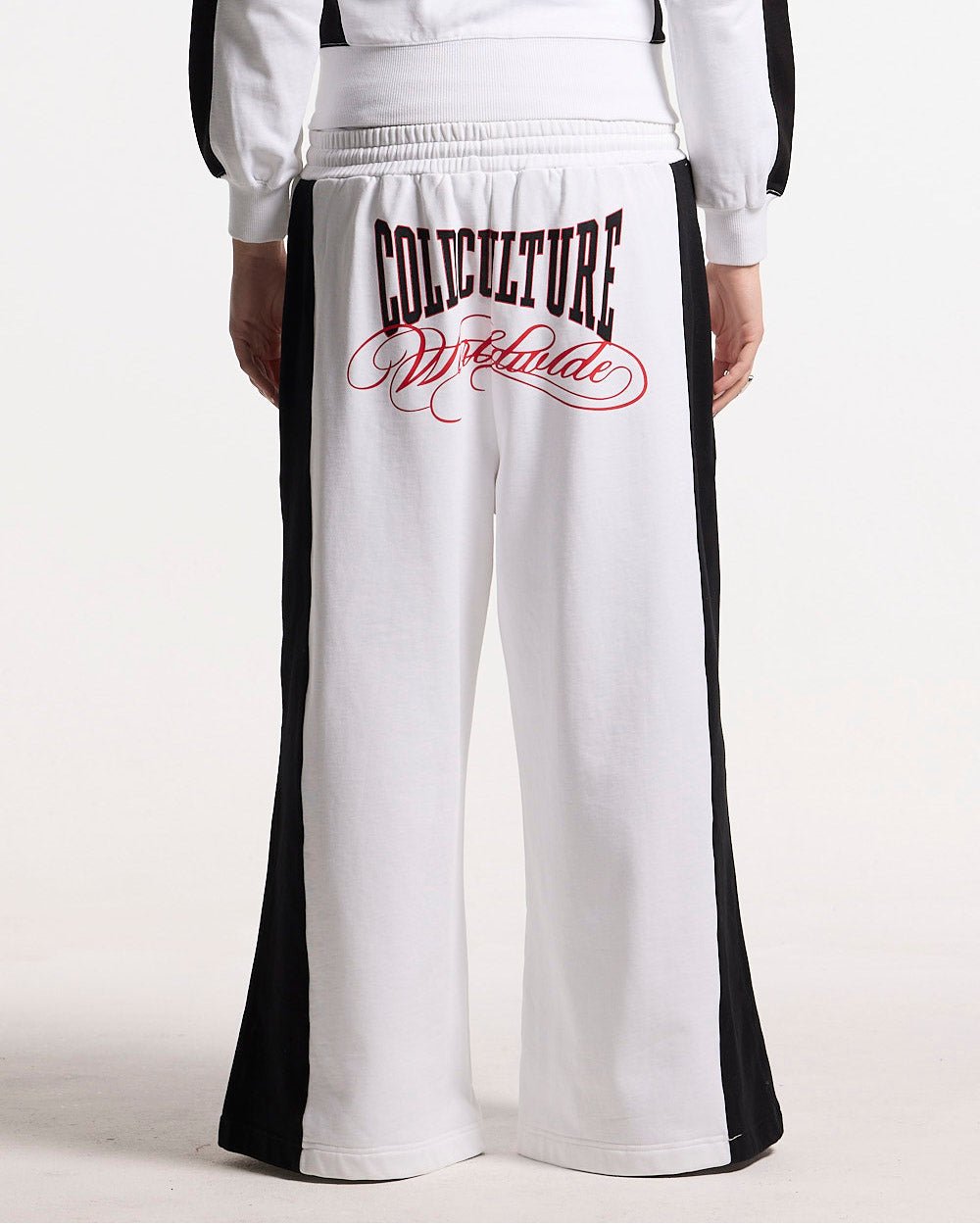 NIA SET SWEATPANTS WHITE & BLACK - white and black wide-leg sweatpants, back view on female model - Cold Culture #woman