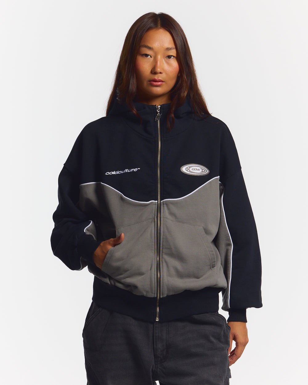 NO RISK ZIP HOODIE BLACK - black and grey colorblock zip-up hoodie, front view on female model - Cold Culture #woman