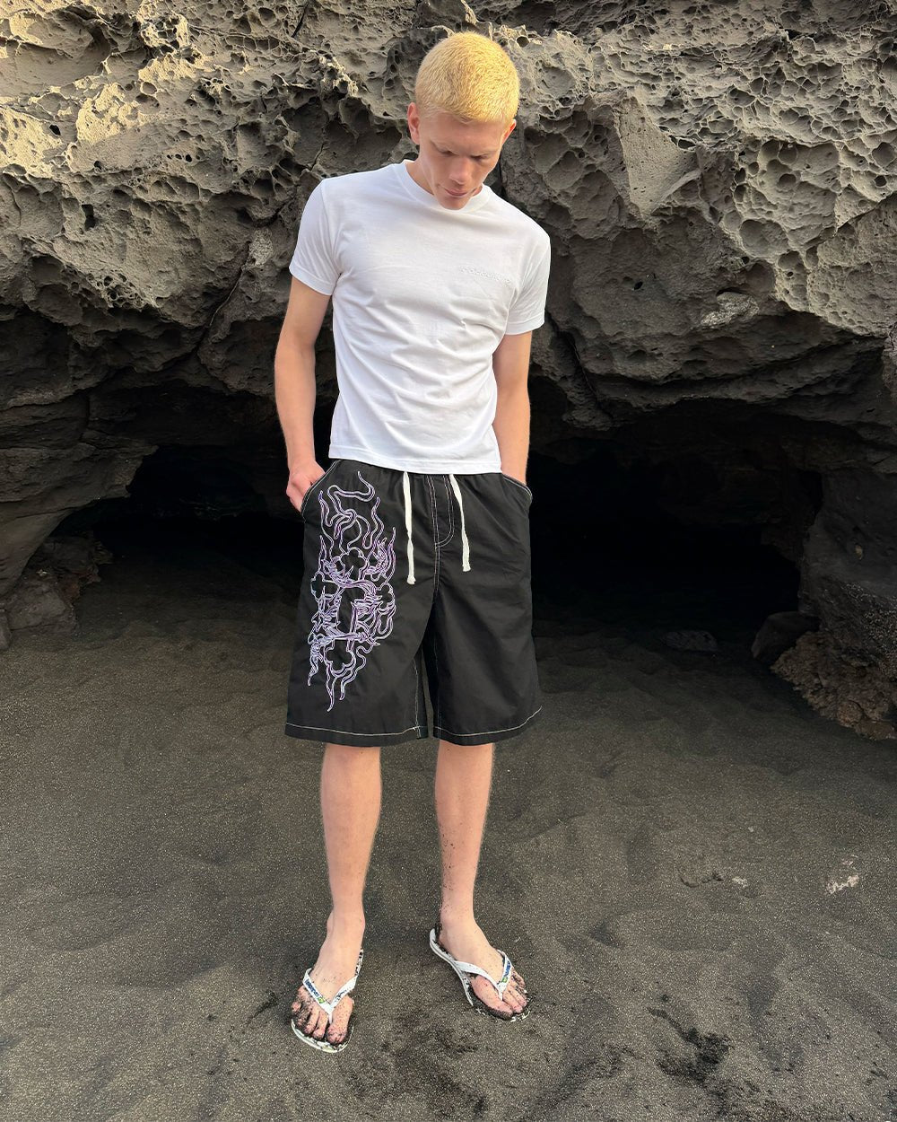 OBSIDIAN SWIMSHORTS BLACK - black embroidered swim shorts, street style shot - Cold Culture