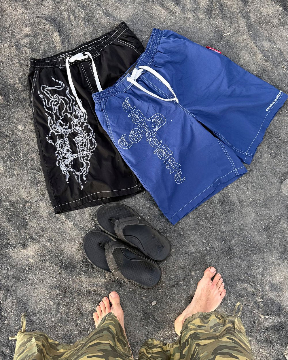 OBSIDIAN SWIMSHORTS BLACK - black embroidered swim shorts, flat lay with matching pieces - Cold Culture