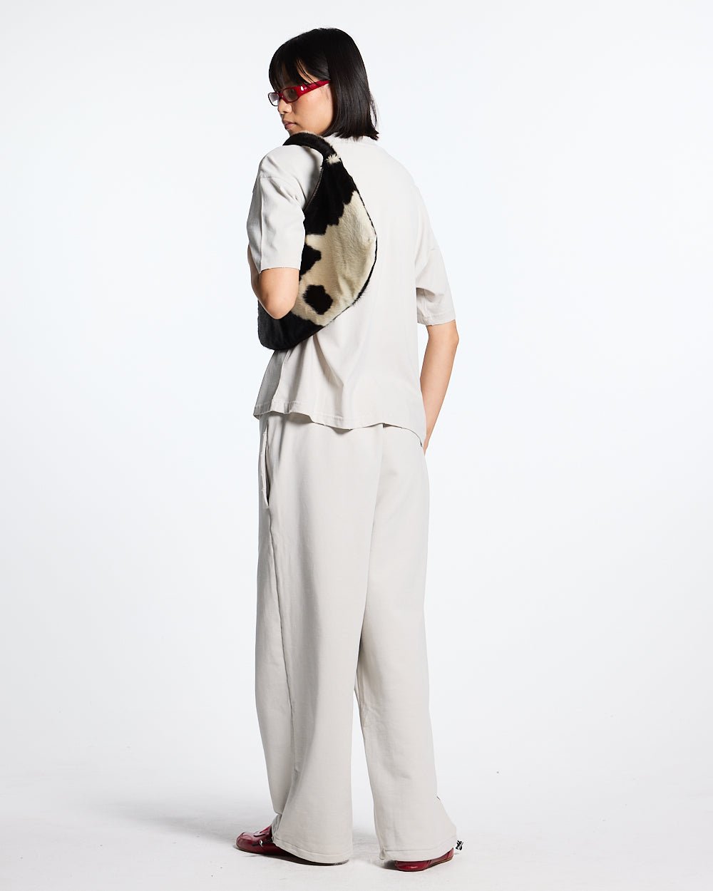 SCRIPT SWEATPANTS LIGHT GREY - light grey script print sweatpants, back view on female model - Cold Culture #woman